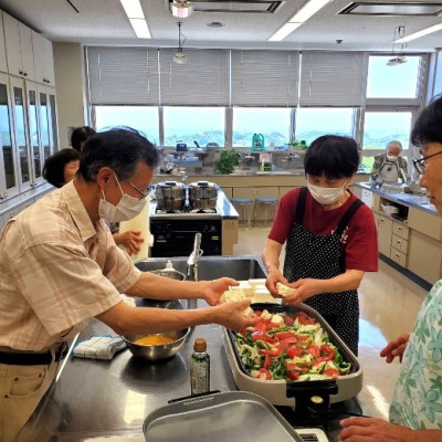 ホットプレートに材料を入れ、豆腐とトマトの炒め物を 作っている様子