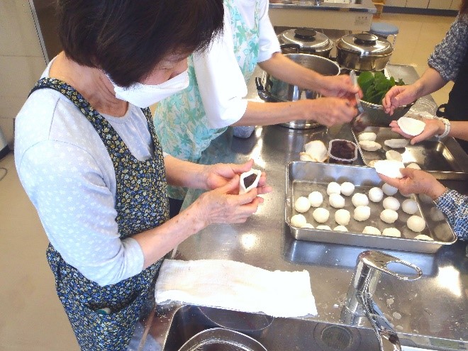 まきだんごにあんこを包んでいる様子