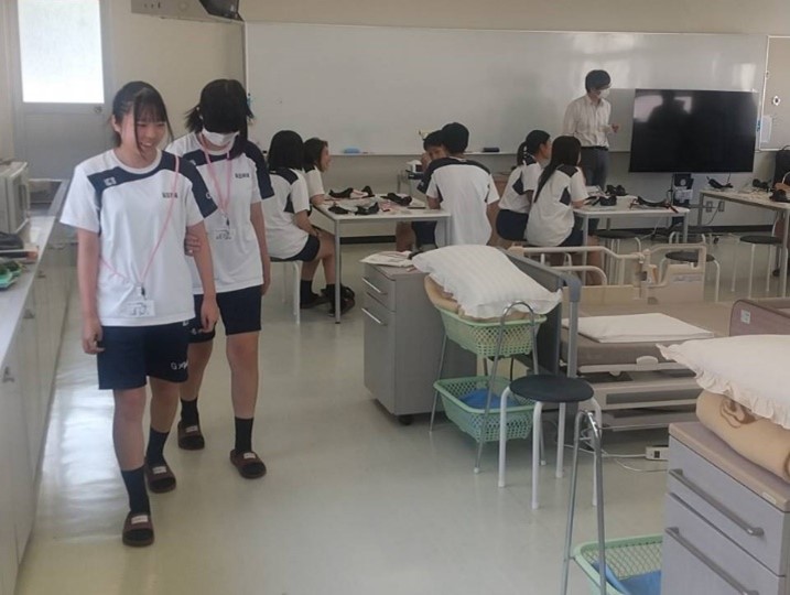 アイマスクをつけ1人が目が見えない状態で、2人1組で段差のない場所を声をかけながら歩く様子。