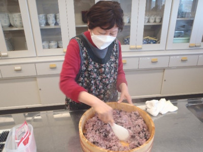 黒豆寿司のご飯に酢を入れ混ぜている様子。