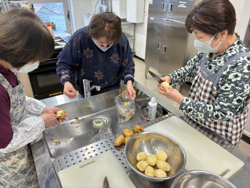 ジャガイモの皮をむき、芽を取っている様子。