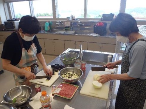 夏野菜カレーに入れるナスや玉ねぎを切っている写真