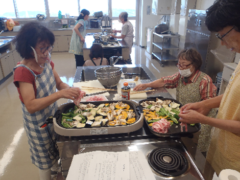 ホットプレートに野菜や肉を並べている写真