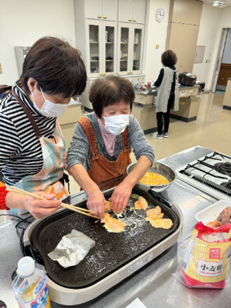 鶏肉に卵をつけてホットプレートに並べている写真