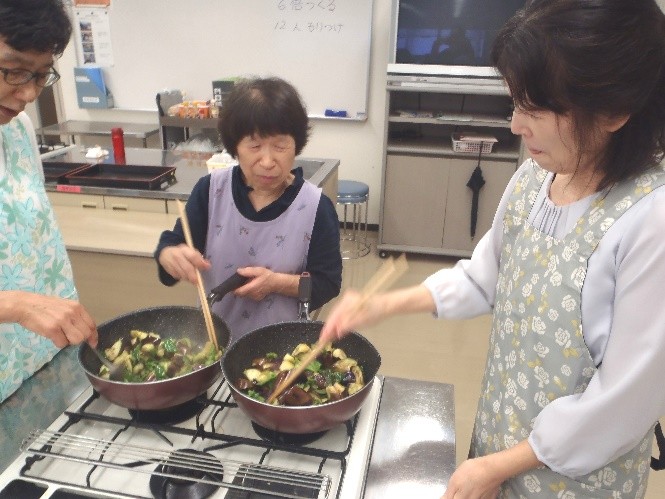 茄子とピーマンのしぎ焼きの材料をフライパンで炒めている様子。
