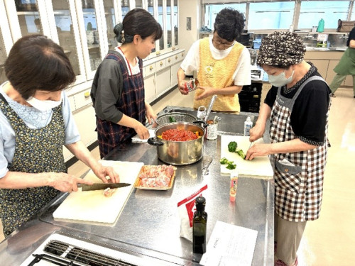 夏野菜のトマト煮の食材を切り、鍋に入れている様子。