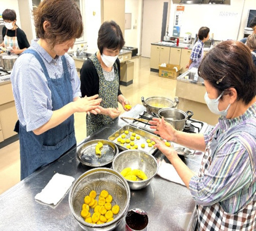 かぼちゃを混ぜた白玉を手で丸め、茹でている様子。