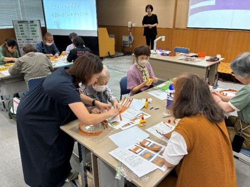 須田先生に作り方を聞きながらかごを組んでいる様子。