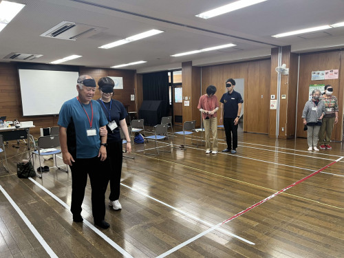 ペアになり手引き歩行の体験をしている参加者