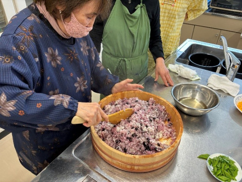 ご飯に酢を入れ混ぜている様子。