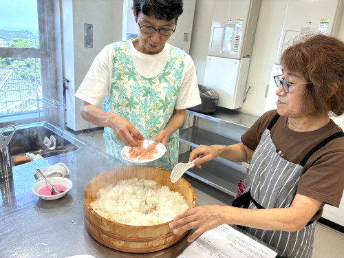 千切りにした甘酢生姜を炊いたご飯に混ぜ合わせる様子。